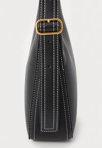 Borsa nera in pelle con una forma strutturata, cuciture bianche ben evidenti e una fibbia in metallo dorato sulla tracolla. Texture liscia, design minimale.