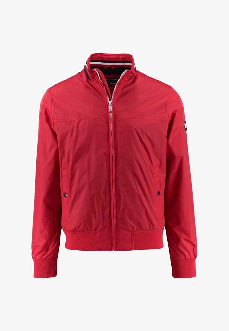 Veste légère rouge à fermeture éclair, poignets et bas côtelés, col montant avec doublure intérieure rayée, et poches latérales à boutons-pression.