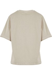 T-shirt beige clair à manches courtes avec une coupe décontractée, un col rond et des détails de couture à l'ourlet. Tissu en coton lisse et sans texture.