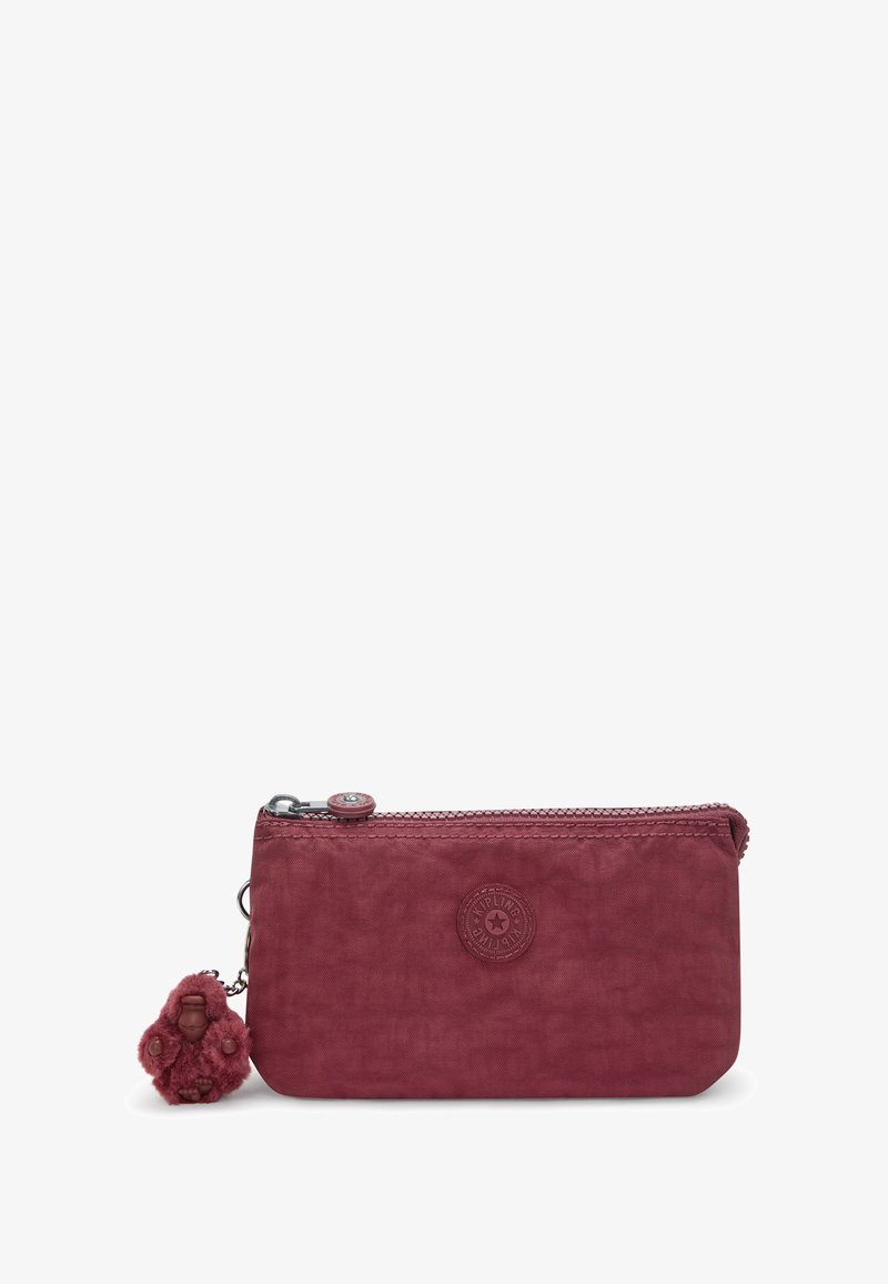Red fabric pouch with a zipper closure, a textured surface, and a decorative furry keychain. Features a circular embossed logo.