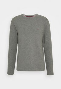 Graues Langarmshirt mit gerippter Textur, Rundhalsausschnitt und kleinem Logo-Detail auf der linken Brust. Klassische Passform.