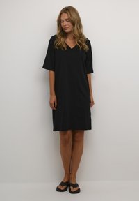 Abito nero a collo a V con maniche corte, realizzato in un tessuto morbido, lunghezza al ginocchio, caratterizzato da una vestibilità comoda e cuciture minime per il massimo comfort.