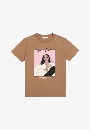 T-shirt en coton marron avec un imprimé graphique représentant une silhouette assise portant des lunettes de soleil, accompagné du texte "Porte ta liberté" en accents roses et noirs.