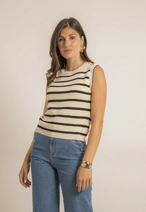 Haut sans manches en crème avec des rayures horizontales noires, col festonné et accents de boutons décoratifs. Associé à un jean taille haute.