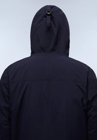 Navy blue hooded jacket with a smooth texture, featuring a cinched hood and horizontal seam across the back. No visible fasteners.