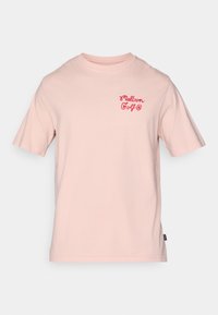 Lyserød bomulds T-shirt med korte ærmer og rund halsudskæring. Har et rødt tekstlogo på venstre brystområde. Klassisk pasform, afslappet design.