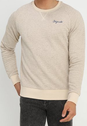 Sudadera de punto beige con rayas texturizadas, cuello redondo, puños y dobladillo acanalados, con un pequeño logo azul en el pecho.