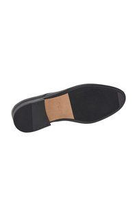 Svart lädersula med en strukturerad gummibotten. Har en slät beige innersula och en distinkt klackdel.