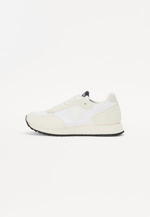 Sneaker bianche con una combinazione di texture liscia e scamosciata, caratterizzate da un logo rotondo, accenti neri sulla linguetta e una suola in gomma nera.