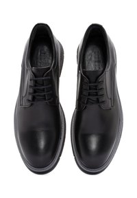 Zwarte lederen héél schoenen met een soepele textuur, ronde neuzen, vetersluiting en minimalistische details. Rubberzolen met een lichte verhoging.