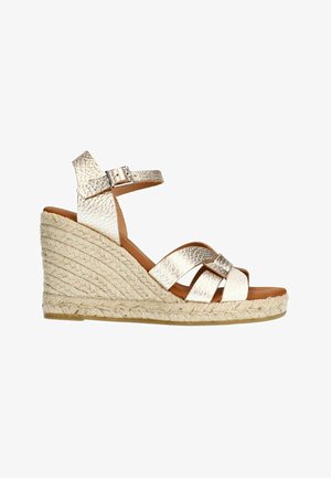 Wedge sandals with a textured metallic gold upper, an adjustable ankle strap, and a braided jute sole. Open-toe design.