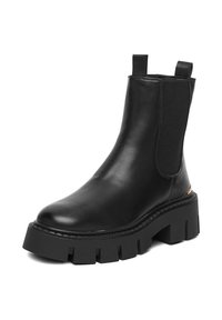 Czarne skórzane botki chelsea z elastycznymi panelami po bokach, zaokrąglonym noskiem i grubą, wyprofilowaną gumową podeszwą. Wyposażone w uchwyty umożliwiające łatwe zakładanie.