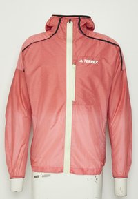 Rote leichte Jacke mit Reißverschluss vorne, Kapuze und schwarzen Akzenten. Sie besteht aus einem strukturierten Stoff und hat ein kleines TERREX-Logo auf der Brust.