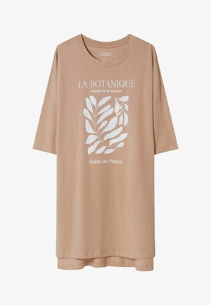 Oversized beżowy t-shirt z białą ilustracją botaniczną i francuskim tekstem "La Botanique Galerie de la Nature Beauté des Plantes" z przodu.