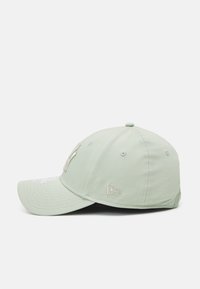 Casquette de baseball vert menthe avec visière incurvée, logo brodé à l'avant et œillets de ventilation. Tissu texturé avec un design structuré.