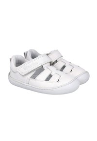 Sandalias de piel blanca con una correa de velcro, diseño de punta abierta y detalles recortados para mayor transpirabilidad. Suave forro interior y suela flexible.