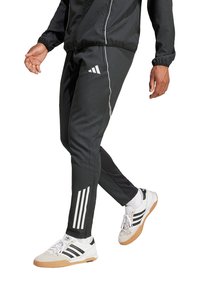 Schwarze Sporthose aus leichtem Material, mit weißen Seitestreifen und besticktem Logo. Slim-Fit-Design und schmal zulaufendes Bein.