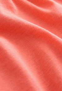 Koralinė medžiaga su minkštu, lygiu paviršiumi. Ši medžiaga yra lengva ir šiek tiek tampri, pasižyminti vienodu, smulkiai megztu raštu.