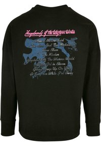 Sort langærmet skjorte med blå og pink grafisk tekst. Teksten inkluderer sangtitler og "Vagabond of the Western World" øverst.