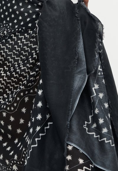 Ύφασμα με ασπρόμαυρο μοτίβο με αστέρια και κυματιστές γραμμές, με ορατές φθαρμένες άκρες.