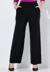 Zwarte wijde broek van zachte stof, met zijzakken en een platte tailleband. Het ontwerp biedt een ontspannen pasvorm.