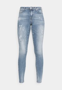 Vaqueros ajustados en denim azul claro, con un acabado desgastado, áreas rasgadas y detalles de arrugas sutiles. Diseño clásico de cinco bolsillos.