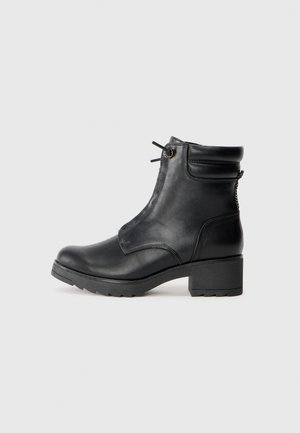 Sorte lær ankle boots med rund tå, sidelås og teksturert såle. Designet har minimal søm og lav blokkheel.