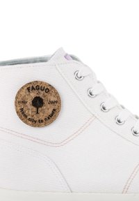Sneaker in tela bianca con un patch in sughero e testo stampato. Eyelets in argento e dettagli di cucitura leggera arricchiscono il design.