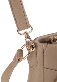 Tracolla in pelle beige con texture, dotata di clip e accessori in metallo dorato, che mostra un primo piano del fissaggio alla borsa.