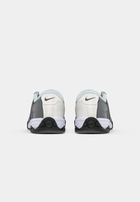 Ténis Nike com um upper branco liso, detalhes cinzentos, colarinho azul claro e sola preta. Apresenta o logótipo perto do calcanhar e um solado com padrão.