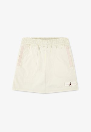 Cream-colored shorts made of lightweight fabric, featuring a smocked waistband, two front pockets, and a logo patch with a silhouette.