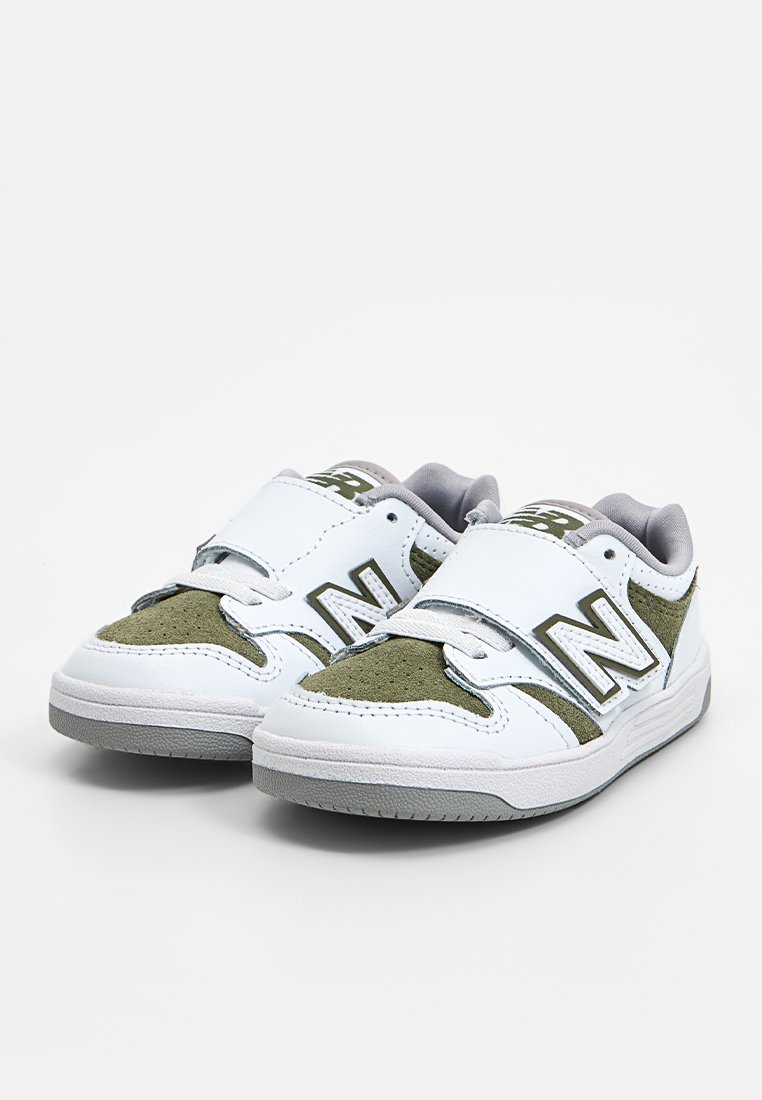 Witte sneakers met olijfgroene accenten, gemaakt van suede en leren materialen, voorzien van een klittenbandsluiting, grijze voering en rubberen zool.