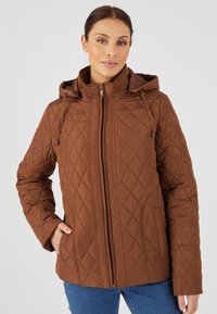 Giacca imbottita marrone con cappuccio, caratterizzata da una cucitura a rombi, una zip frontale e tasche laterali. Realizzata in un tessuto liscio e caldo.