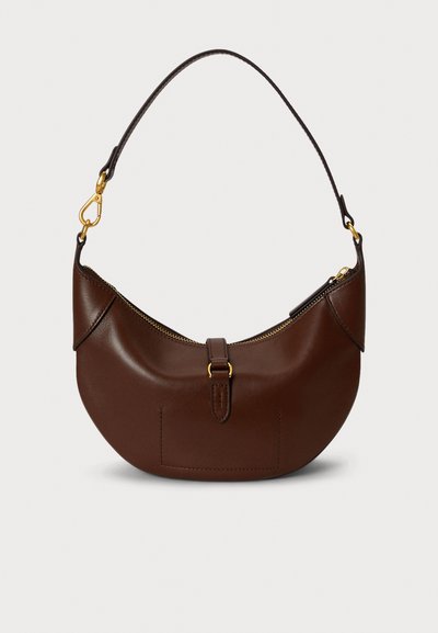 Καφέ δερμάτινη τσάντα χειρός με καμπυλωτό σχήμα, που διαθέτει χρυστό φερμουάρ και μεταλλικά στοιχεία, καθώς και κοντό ιμάντα για μεταφορά. Ομαλή υφή με ελάχιστες λεπτομέρειες.