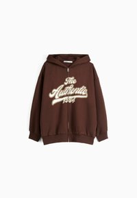 Hnědá zipová mikina s velkým krémovým grafickým nápisem "The Authentic 1994" na přední straně. Má kapuci a žebrované manžety na rukávech.