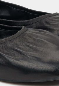 Czarne skórzane baleriny o miękkiej, pomarszczonej fakturze i niskim kroju. Szwy na krawędziach oraz zaokrąglony kształt palców.