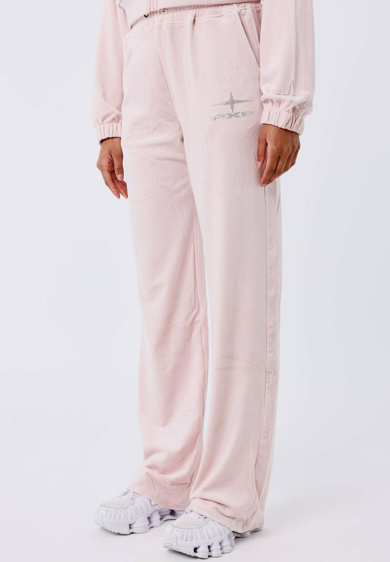 Lichtroze sweatpants gemaakt van zachte stof. Voorzien van een elastische tailleband en zijzakken. Inclusief een zilveren ster ontwerp op de linkerdij.