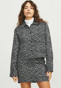 Juostelės rašto marškiniai ir sijonas, juodos ir pilkos spalvos, su apykakle, mygtukų užtrauktuku ir ilgomis rankovėmis. Minkšta tekstūra.