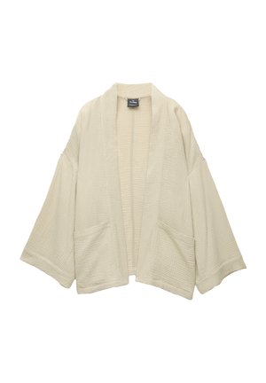 Light beige kimono with wide sleeves and two front pockets. Textured fabric with a grid pattern. Open front design.