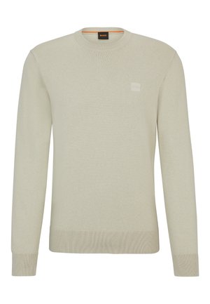 Beżowy sweter z długim rękawem i okrągłym dekoltem, z prążkowanymi mankietami i dołem, z małą wytłoczoną naszywką z logo na piersi.