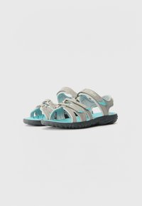 Light gray sandals with blue accents; adjustable straps and open design; textured gray rubber sole; designed for comfort and durability.