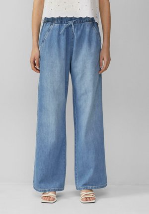 Lichtblauwe wijde denim broek met een elastische tailleband en trekkoord, voorzien van zijzakken en een losse pasvorm. Gevoel van een gladde textuur.