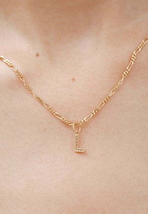 Collar de cadena de oro con un diseño de eslabón retorcido y un pequeño colgante "L" adornado con joyas. El colgante cuenta con acentos claros y brillantes.