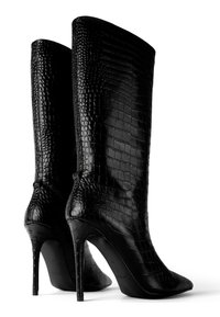 Fekete magassarkú csizma, textúrált műbőrből, krokodilbőr mintázattal. Jellemzője a hegyes orr és a vékony stiletto sarok.