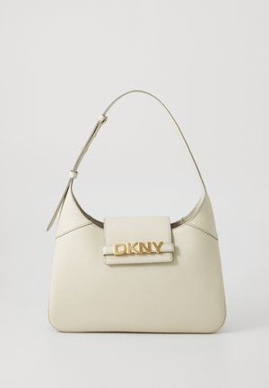 Borsa a tracolla in pelle beige con forma strutturata, manico singolo, chiusura magnetica e logo "DKNY" in tonalità oro sul davanti. Texture liscia.