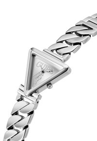 Reloj triangular plateado con una correa de acero inoxidable pulido. Presenta una esfera clara y un logo de marca destacado. Superficies suaves y reflectantes.