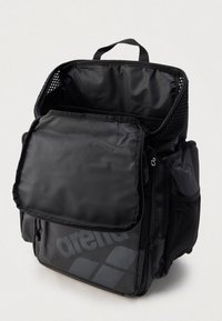 Zaino nero con più scomparti, dotato di patta anteriore e dettagli in rete. Realizzato in tessuto resistente, con un grande logo del marchio ben visibile.