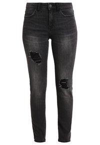 Kapeen mustat farkut, joissa on kuluneet polvitoiminnot. Niissä on klassinen viisi-taskumalli ja nappikiinnitys. Hienovaraista haalistumista kauttaaltaan.