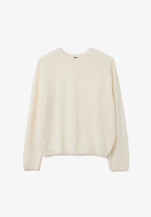 Suéter de punto color crema con cuello redondo, puños acanalados y detalles en las costuras de los hombros. textura suave y corte relajado.