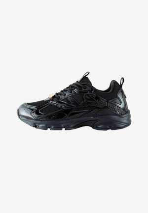 Schwarzer Sneaker mit gemischtem Mesh und glänzenden Einsätzen, Schnürverschluss, dicker Sohle und Zuglaschen an Ferse und Zunge, Seitenansicht.